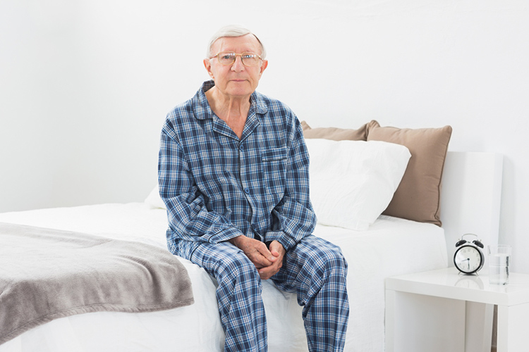 A patient sitting on the edge of their bed. physiotherapy