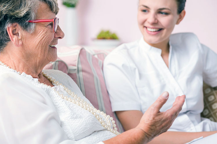 older woman talking to nurse happily