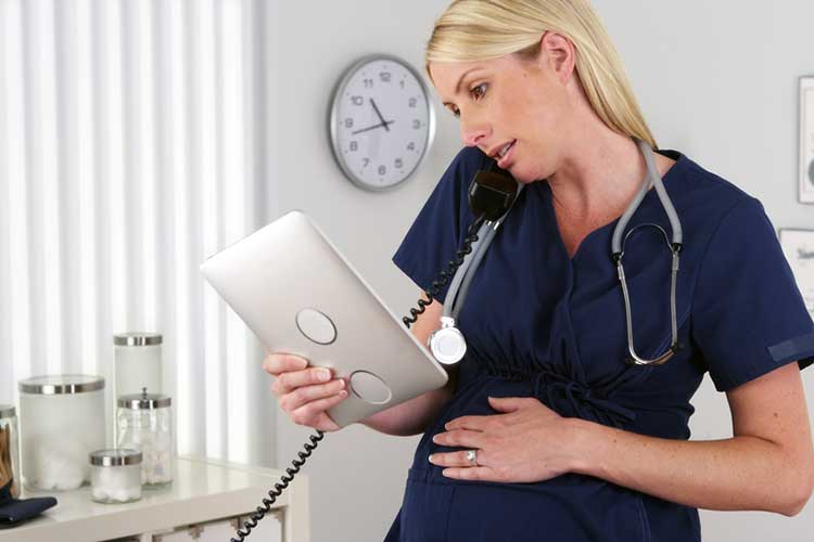 Working as a Nurse During Pregnancy - Are You a Pregnant Nurse? pregnant nurse on ipad