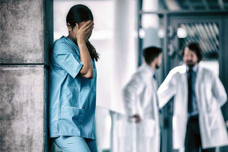 Female nurse with hand on face in shame