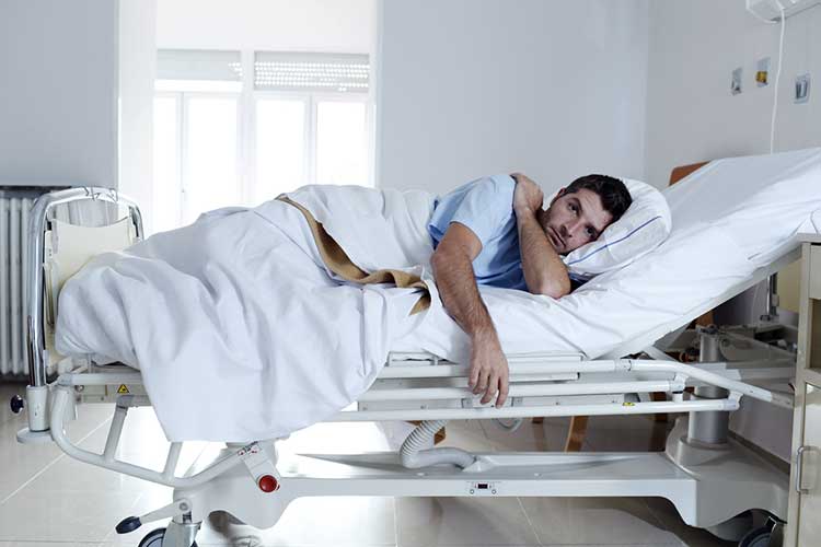 Male patient lying on his side in a hospital bed