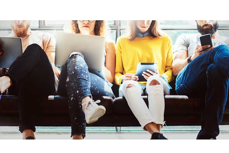 four people using devices on public transport